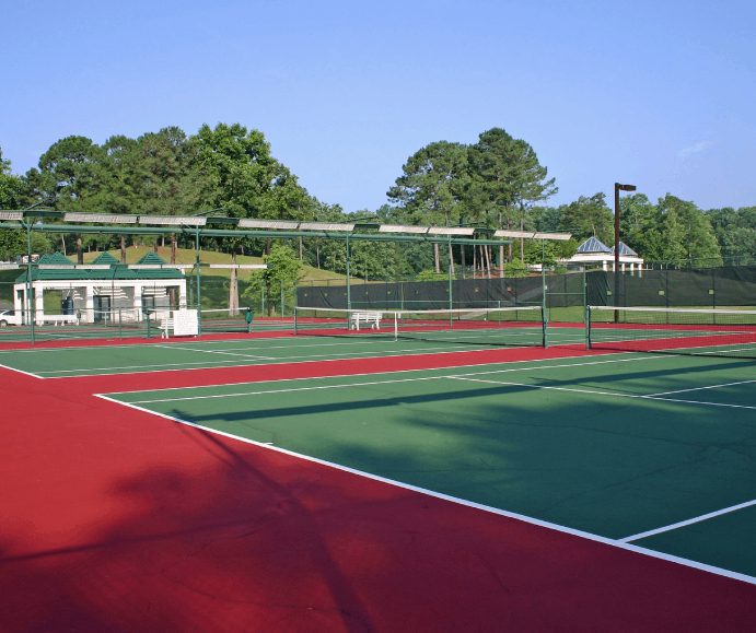 A tennis court with two different colors of red and green.
