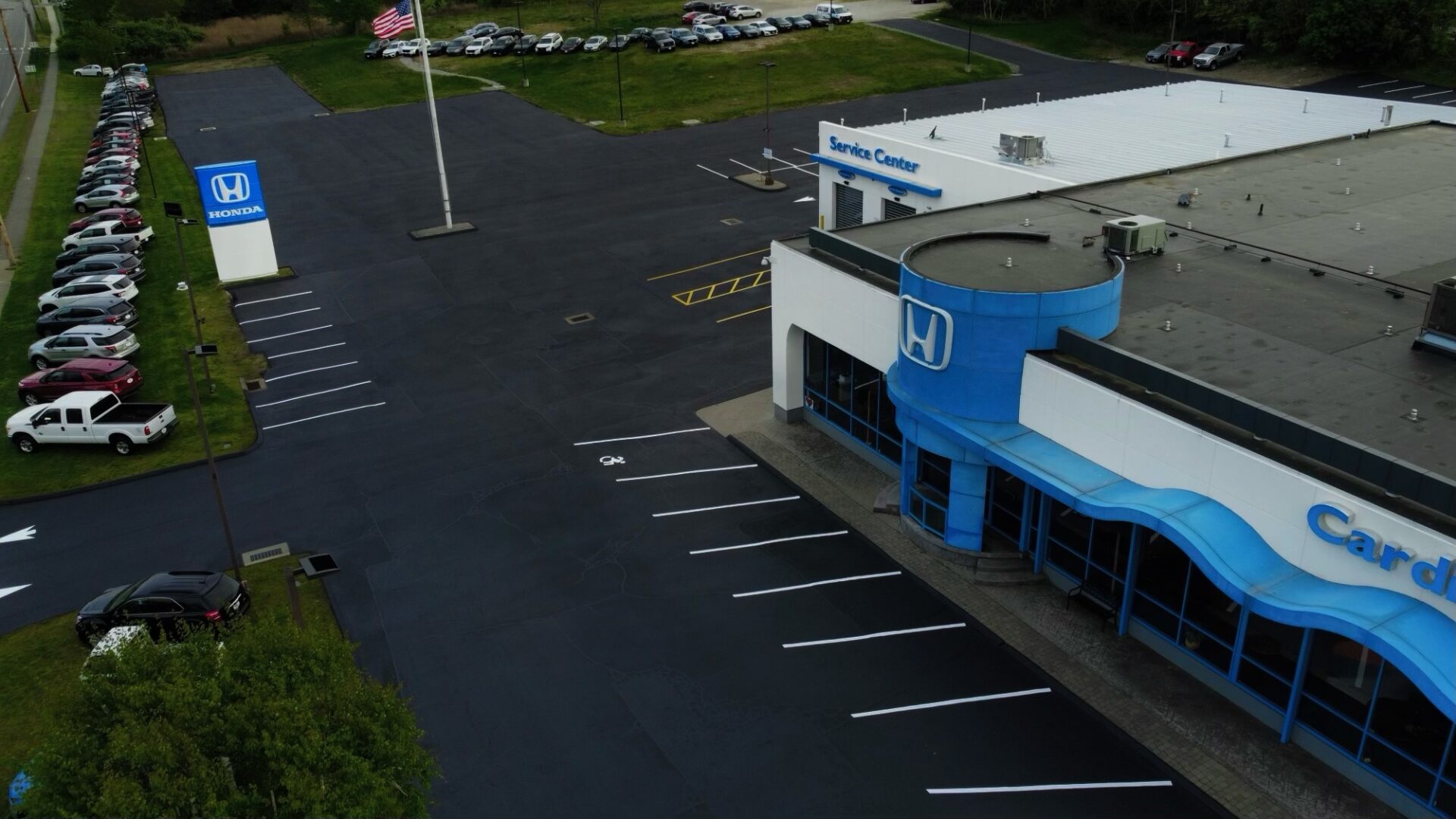 A car dealership with a blue and white building.