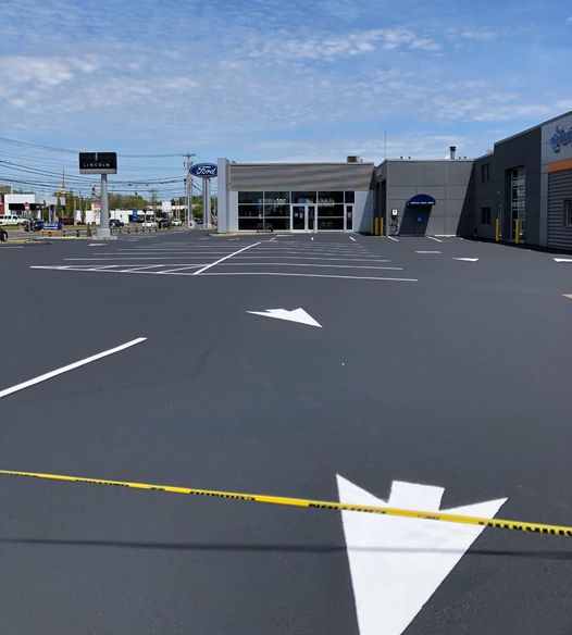 A parking lot with white lines and arrows on it.