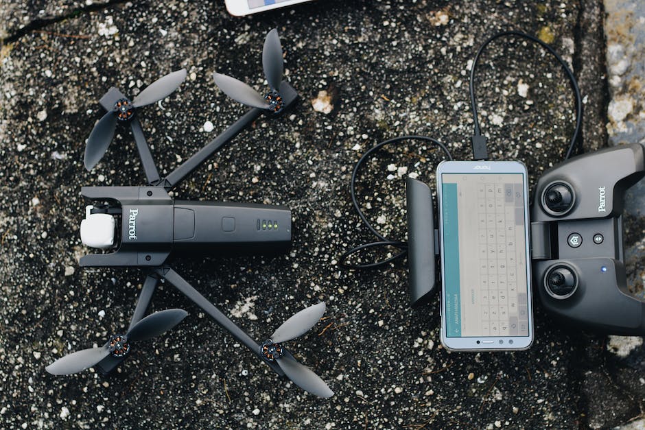A cell phone and a camera are laying on the ground.