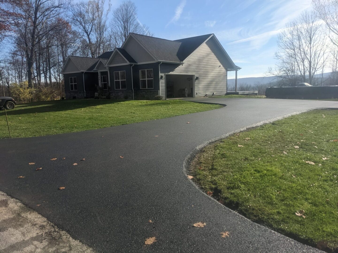 A house with a driveway and grass in front of it.
